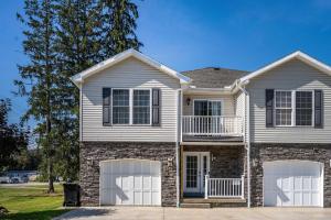 a house with two white garage doors on it at Family Friendly Spacious 4BR Townhome Hot Tub less than 1 mile to town in Ellicottville