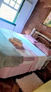 a bed sitting in a room with a window at Ohana pouso campestre e camping in Tiradentes