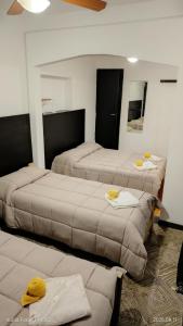 a room with three beds in a room at Hotel LE MIRAGE in Mar del Plata
