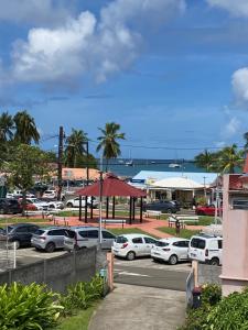 a parking lot with cars parked in front of a harbor at Les Orchidées - classé 3 étoiles -Plage à 5 mn in Sainte-Anne