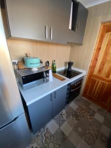 a small kitchen with a microwave and a sink at Casa con piscina in Bahia Inglesa