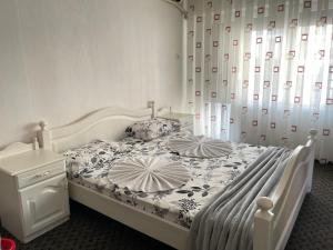 a bedroom with a white bed with two pillows on it at Motel Albatros in Kosovo Polje