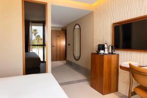 a hotel room with a bed and a flat screen tv at Villa Sahrai, a Member of Design Hotels in Casablanca +87 photos