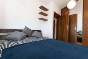 - une chambre avec un lit bleu et 2 oreillers dans l'établissement Sole, à Gdańsk