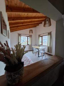 a living room with a table and a potted plant at Mirador del Bosque Aparts in El Chalten