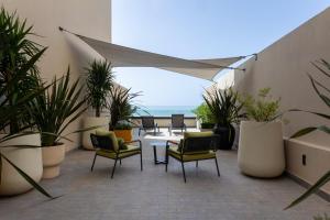 a patio with chairs and potted plants and the beach at Villa Sahrai, a Member of Design Hotels in Casablanca