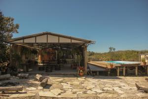 einen Pavillon mit einem Picknicktisch und einem Pool in der Unterkunft Casa Borba Chalé em Alto Paraíso de Goiás in Alto Paraíso de Goiás
