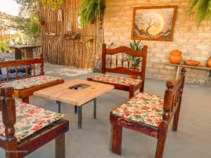 eine Gruppe von Stühlen und ein Holztisch und eine Bank in der Unterkunft Casa Borba Chalé em Alto Paraíso de Goiás in Alto Paraíso de Goiás