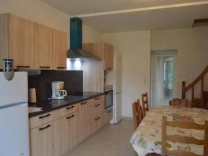 a kitchen with a white refrigerator and a table with a table sidx sidx at Maison de plain-pied avec grand jardin clos et parking, à 10 min des vignes. - FR-1-591-223 in Reuilly