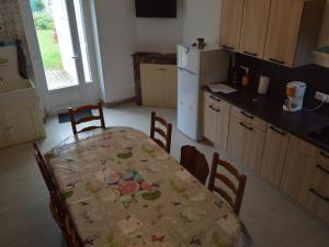 a kitchen with a table and chairs and a refrigerator at Maison de plain-pied avec grand jardin clos et parking, à 10 min des vignes. - FR-1-591-223 in Reuilly