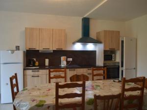 a kitchen with a table and chairs and a white refrigerator at Maison de plain-pied avec grand jardin clos et parking, à 10 min des vignes. - FR-1-591-223 in Reuilly +2 photos