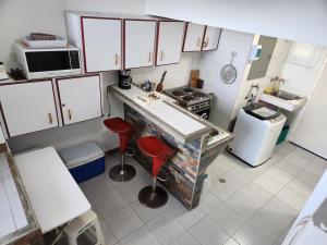 an overhead view of a kitchen with a stove and stools at TUCACAS PENTHOUSE VISTA AL MAR y SALIDA A LA PLAYA in Tucacas