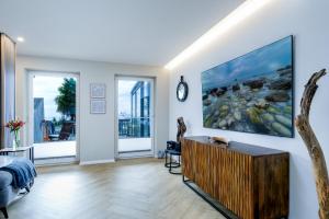 a living room with a large painting on the wall at FeWo Ostsee Lounge - Meerblick, Sauna, Terrasse in Sassnitz