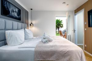 a teddy bear sitting on a bed in a bedroom at FeWo Ostsee Lounge - Meerblick, Sauna, Terrasse in Sassnitz