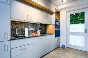 a kitchen with white cabinets and a sink at FeWo Ostsee Lounge - Meerblick, Sauna, Terrasse in Sassnitz