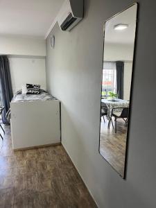 un miroir sur un mur dans une pièce avec une table dans l'établissement Planta Alta con Balcon, à Mar del Plata