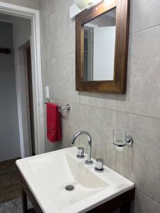 une salle de bains avec un lavabo blanc et un miroir dans l'établissement Planta Alta con Balcon, à Mar del Plata 1 autre photo