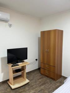 une chambre avec une télévision et une armoire en bois dans l'établissement Planta Alta con Balcon, à Mar del Plata