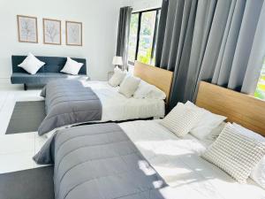 a bedroom with three beds and a couch at Palm Breeze Getaway in Hollywood