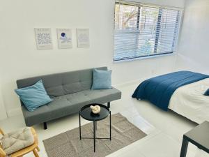 a living room with a couch and a bed at Palm Breeze Getaway in Hollywood