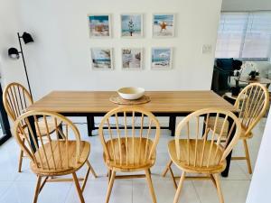 a dining room with a wooden table and four chairs at Palm Breeze Getaway in Hollywood