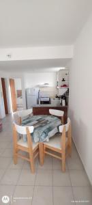Una habitación con una mesa y sillas y una cocina. en Sea&Whales lllc, en Puerto Madryn