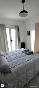 Un dormitorio con una cama y una ventana grande. en Sea&Whales lllc, en Puerto Madryn