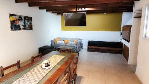 a living room with a couch and a tv at Casa Centrica con Cochera Privada y Portón Eléctrico para facil acceso in San Nicolás de los Arroyos