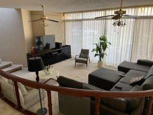 a living room with a couch and a tv at Villa Providencia in Guadalajara