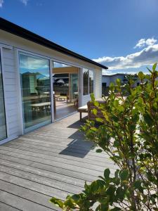 une terrasse en bois avec un banc sur une maison dans l'établissement Seacrest, à Ohakana Island