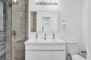 a white bathroom with a sink and a shower at Palm Breeze Retreat in Hollywood +19 photos
