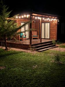 una cabina con luci sul ponte di notte di Amuleto Cabañas, Bella Vista, Maldonado a Bella Vista