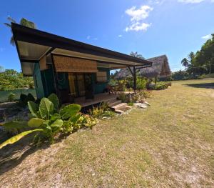 a small house with a thatched roof at Rangiroa Te Manuia Lodge in Rangiroa