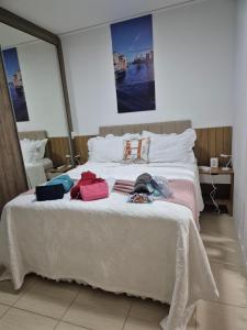 a bedroom with a white bed with clothes on it at Loft, seu espaço com conforto in Mogi das Cruzes