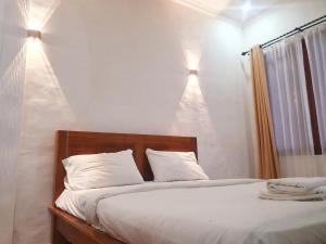 En eller flere senge i et værelse på Gana Bali Guest House