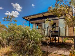 a glass house on the side of a hill at Casa Borba Chalé com piscina in Alto Paraíso de Goiás