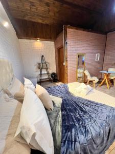 een slaapkamer met een groot bed met kussens bij Flat Girassol Santo Antônio do Pinhal in Santo Antônio do Pinhal