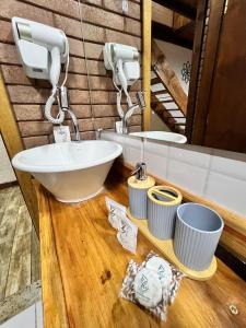 een badkamer met een wastafel en een spiegel bij Flat Girassol Santo Antônio do Pinhal in Santo Antônio do Pinhal