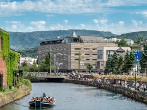 een groep mensen in een boot op een rivier bij Granbell Hotel Otaru in Otaru