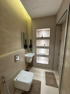a bathroom with a toilet and a sink at Luxurious suite with a terrace overlooking KAFD in Riyadh +61 photos