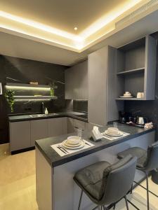a kitchen with a island with chairs and a counter top at Luxurious suite with a terrace overlooking KAFD in Riyadh