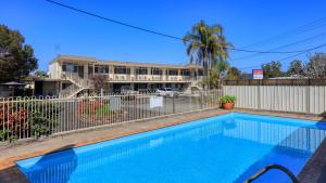 a swimming pool in front of a building at Waterview Motel Maclean in Maclean