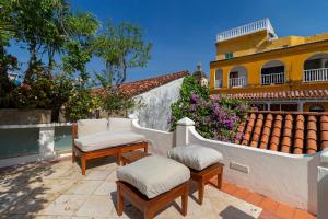 two ottoman chairs sitting on a patio in front of a house at Heated pool Spectacular House Historic Center in Cartagena de Indias