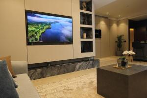 a living room with a large flat screen tv on a wall at Luxurious suite with a terrace overlooking KAFD in Riyadh