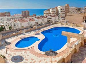 a large swimming pool on top of a building at Costamar bungalow familiar, piscina y terraza, a 5 min de la playa in Arenales del Sol