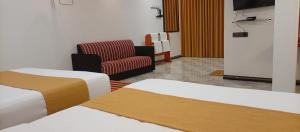 een hotelkamer met twee bedden en een stoel bij Best View Guest Inn Ella in Ella