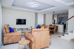 a living room with couches and a dining room at A Beautiful home, Kanombe, Nyarugunga in Kigali