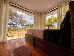 a bedroom with a bed and a large window at Casa Borba Chalé panorâmico in Alto Paraíso de Goiás