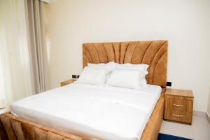 a bedroom with a bed with a wooden headboard at A Beautiful home, Kanombe, Nyarugunga in Kigali