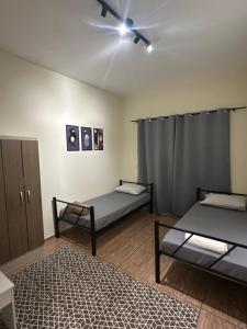 a room with two beds and a ceiling fan at Pousada Araquari in Paraty